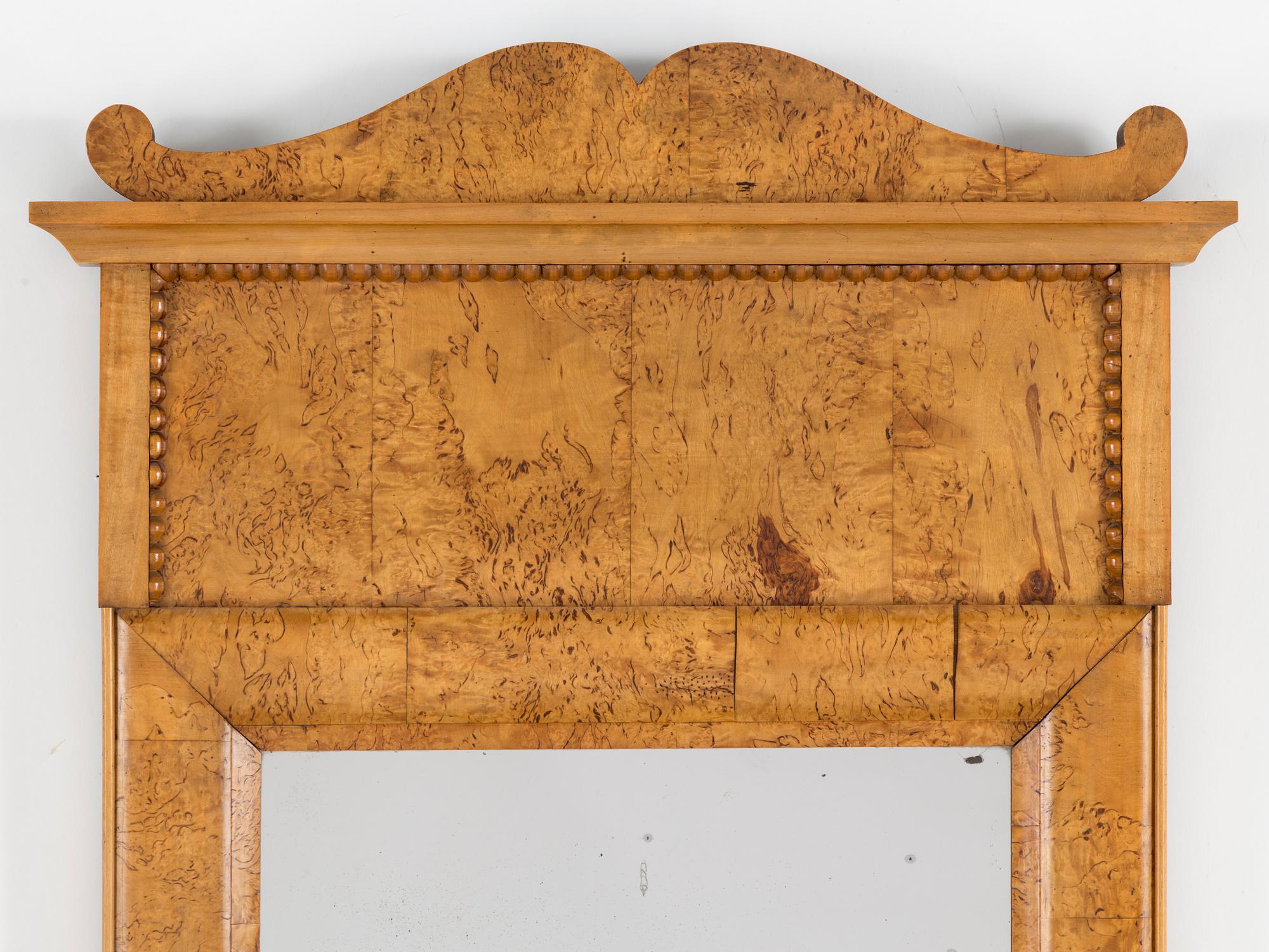 A birch veneered Swedish mirror, late empire, mid 19th Century.
