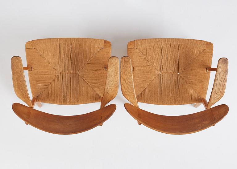 Hans J. Wegner, a pair of "CH 22" oak chairs, Carl Hansen & Son, Odense, Denmark, mid 20th century.