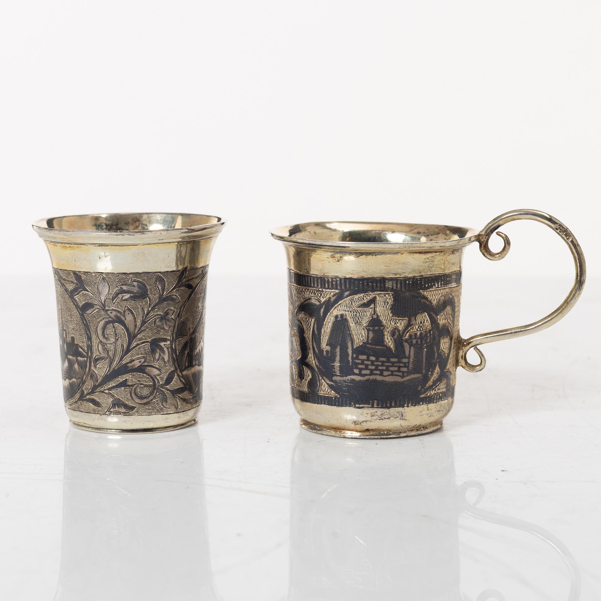 Two Russian parcel-gilt silver niello vodka cups, Moscow 1832 and 1845.