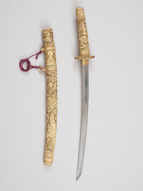 A elaborately sculptured Japanese ceremonial sword, Meiji (1868-1912), with an older blade originally from a long sword.
