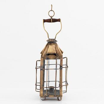 A metal storm lantern, marked A.T, circa 1900.