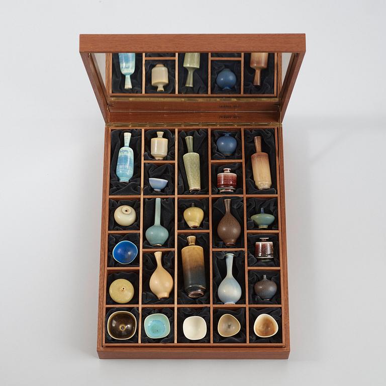 A Berndt Friberg set of 24 miniature stoneware vases and bowls in a teak casket, Gustavsberg Studio.