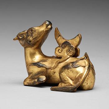 590. A gilt bronze figure of a reclining mythical animal, Qing dynasty, 19th Century.