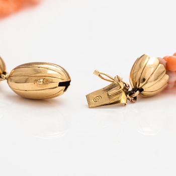 A 6-strand pearl collier with coral pearls and an 18K gold clasp.