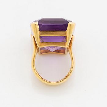 A Tina Karlsson ring in 18K gold set with a faceted amethyst.