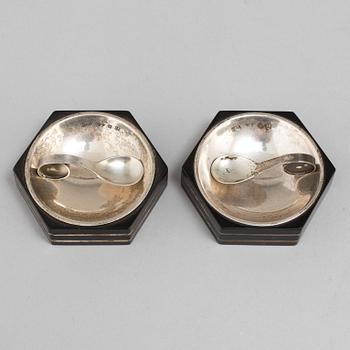 A set of two silver and ebony salt cellars with spoons by Guldsmedsaktiebolaget, Stockholm 1930-46.