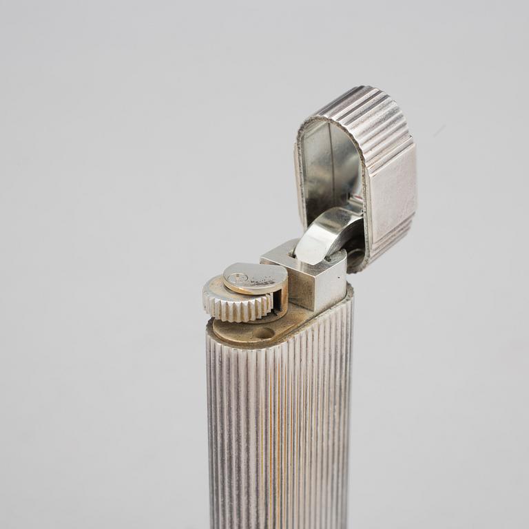 A must de Cartier silver plated cigarette lighter.