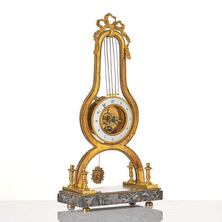 A French Louis XVI ormolu and marble lyre-shaped mantel clock, late 18th century.
