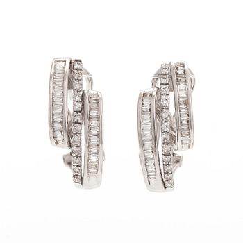 A pair of 18K white gold earrings, set with brilliant- and baguette-cut diamonds.