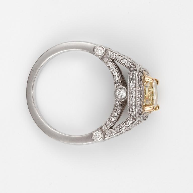 A 1.73 cts Fancy Yellow/VVS2 cushion-cut diamond ring, surrounded by colourless diamonds circa 0.80 cts in total.