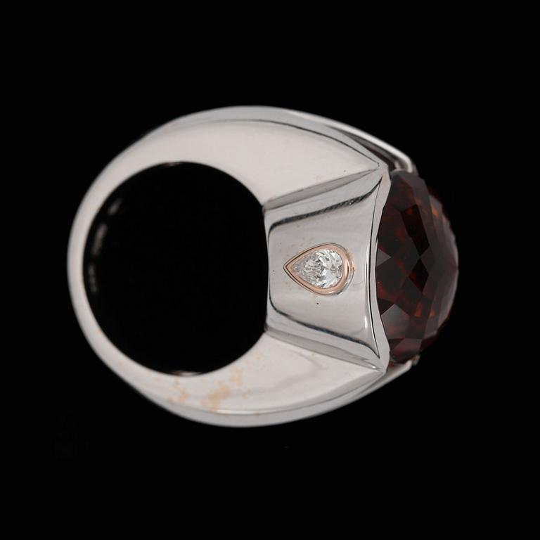 A facett cut garnet ring, 18 cts, with drop cut diamonds, tot. 0.37 ct.