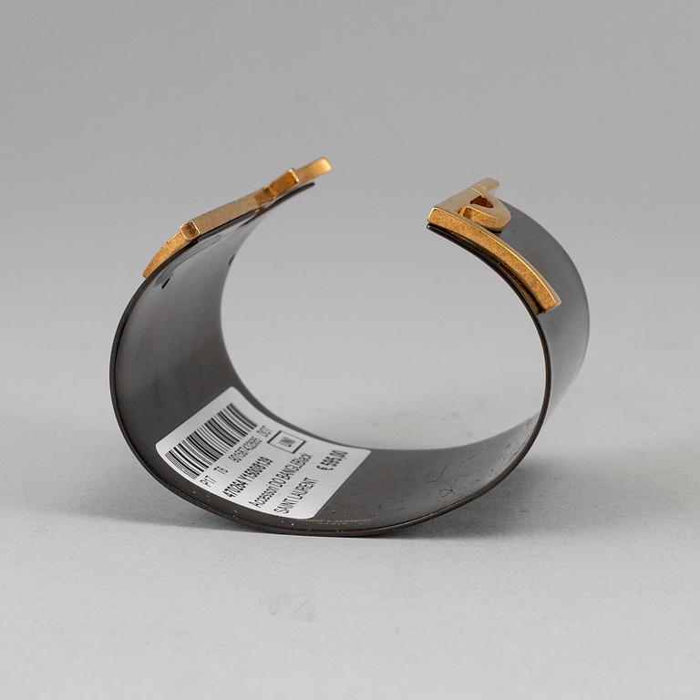 YVES SAINT LAURENT, a metal bangle.