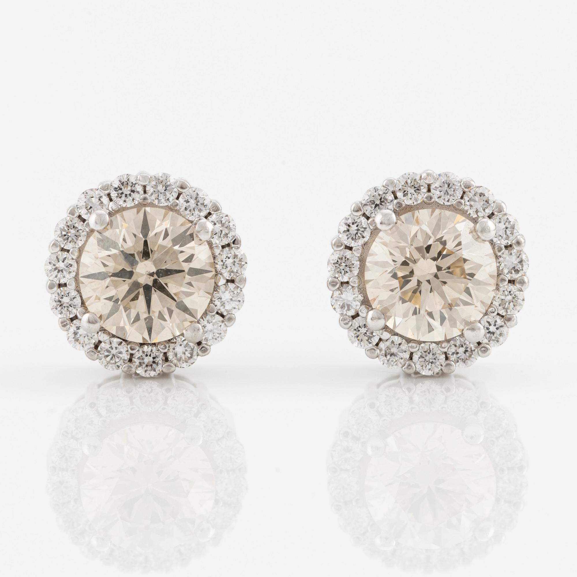 A pair of 18K gold earrings with round brilliant-cut diamonds.