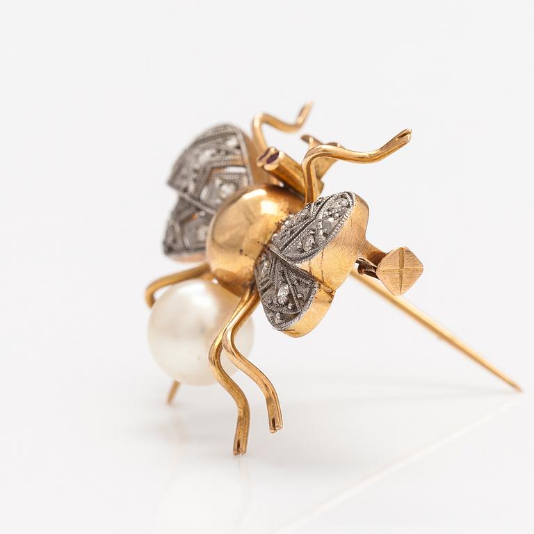 A 15-17K gold brooch with rubies, a cultured pearl and diamonds ca. 0.10 ct in total.