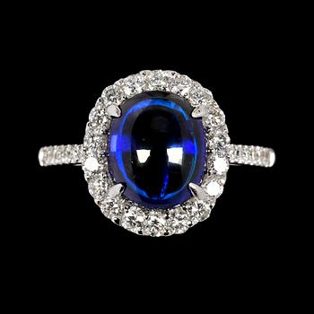 RING, cabochonslipad blå safir, 4.14 ct samt briljantslipade diamanter, tot. 0.68 ct.