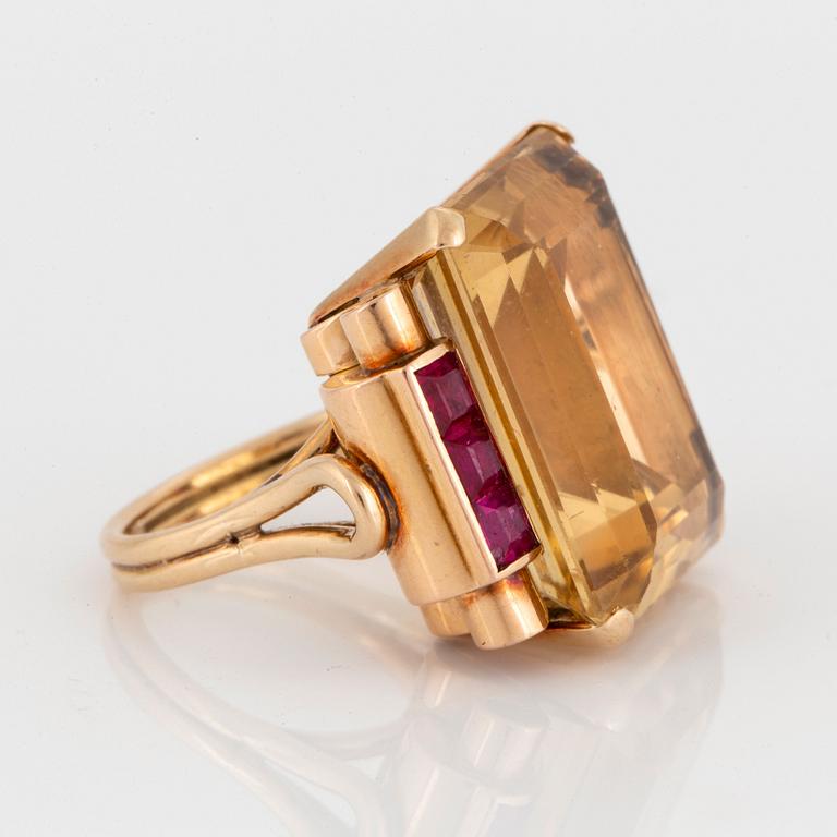 A 14K gold ring set with a faceted citrine and rubies.