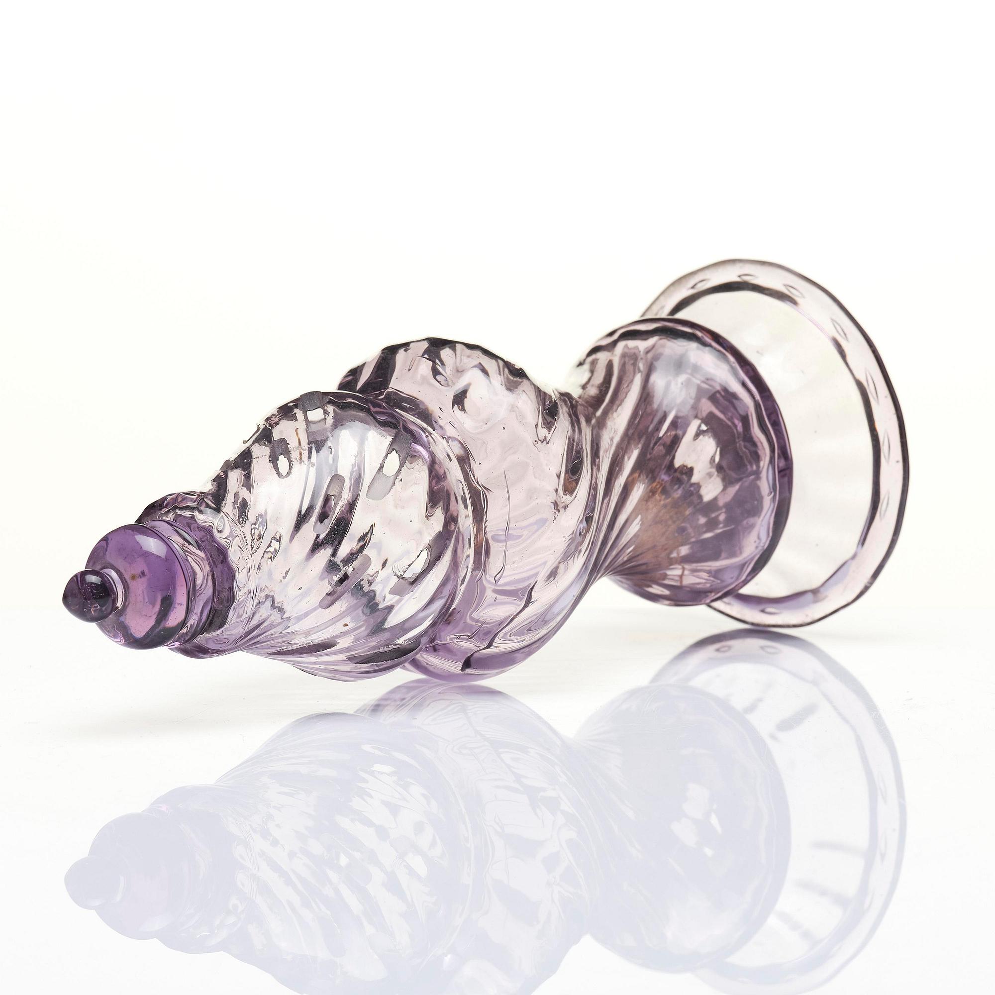 An amethyst coloured suger shaker and a cut glass goblet, 18th century.