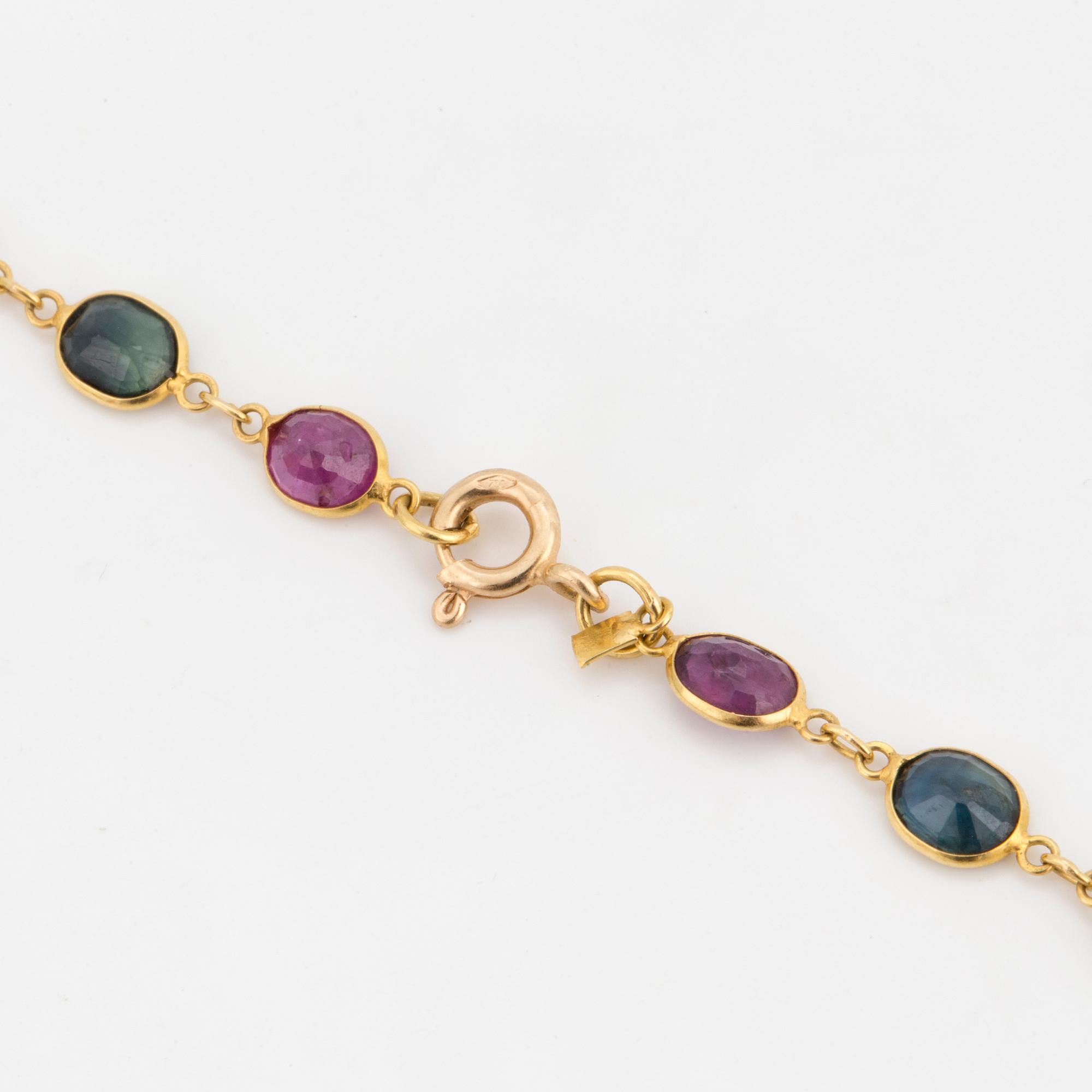 A necklace set with oval, mixed-cut, multi-coloured gemstones.