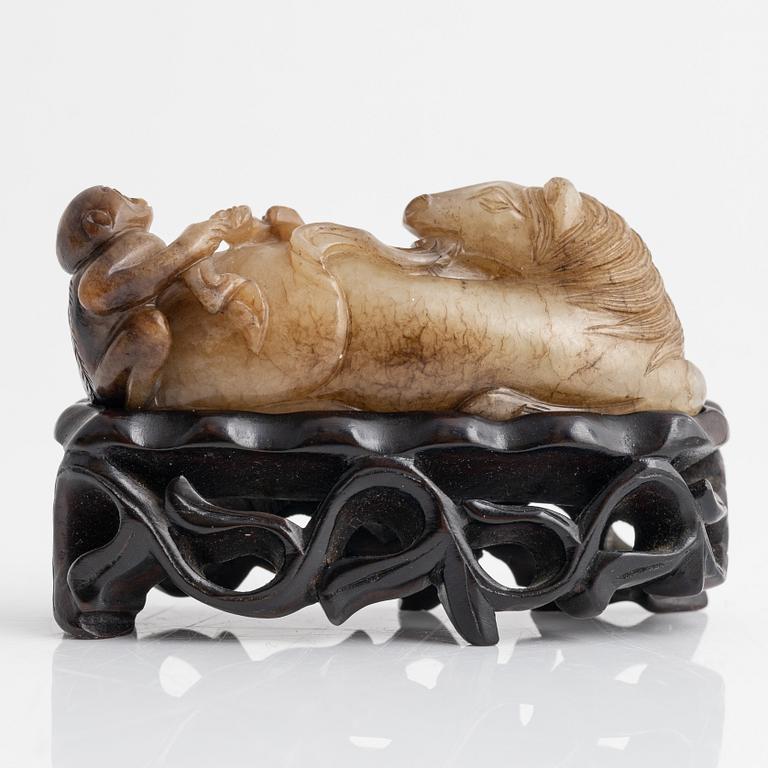 A Chinese sculptured figure of a reclining horse, 20th Century.