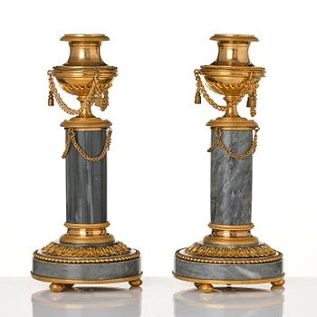 A pair of Louis XVI ormolu and Bleu turquin candlesticks.