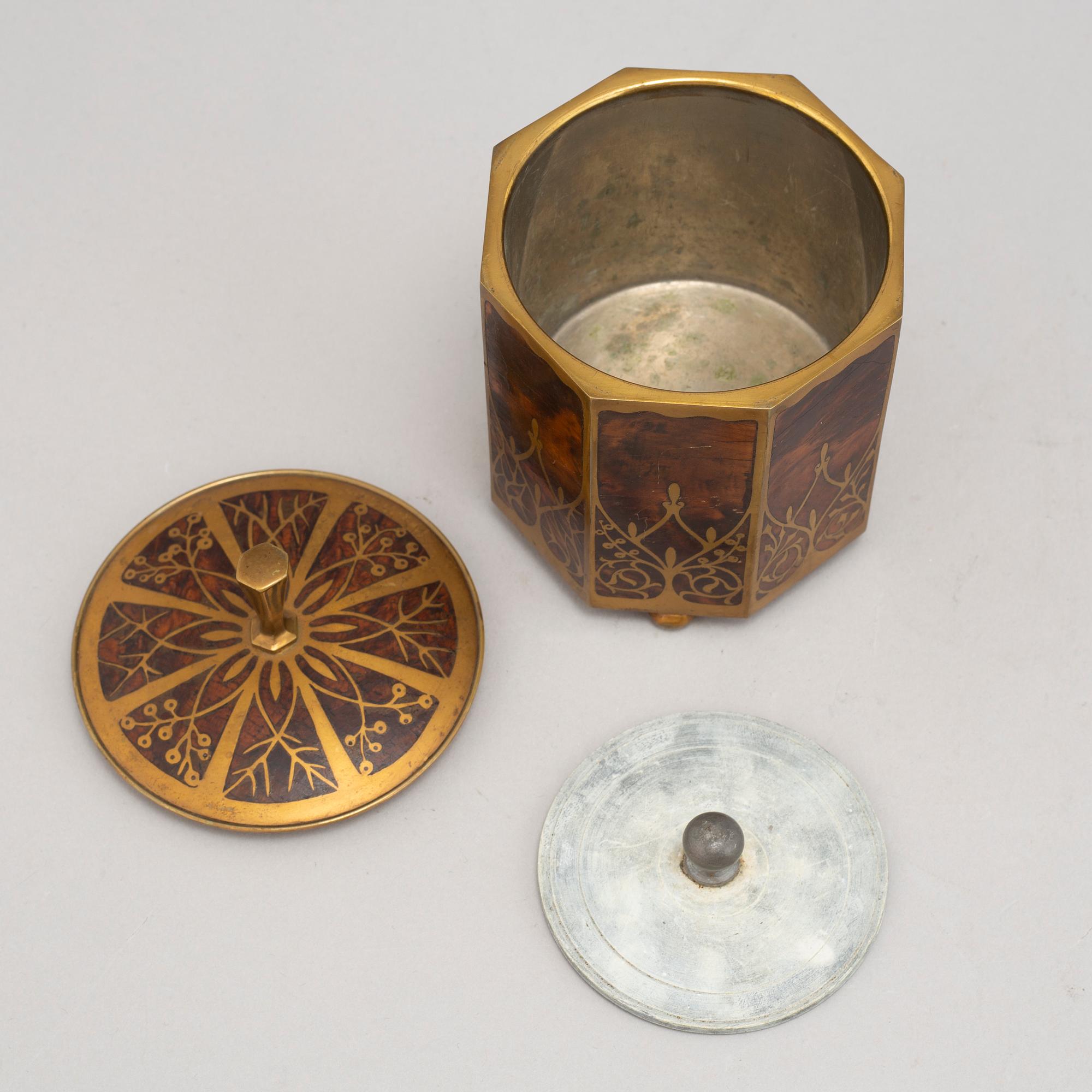 An art nouveau brass and burr walnut tobacco jar and cover from around year 1900.