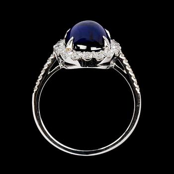 RING, cabochonslipad blå safir, 4.14 ct samt briljantslipade diamanter, tot. 0.68 ct.