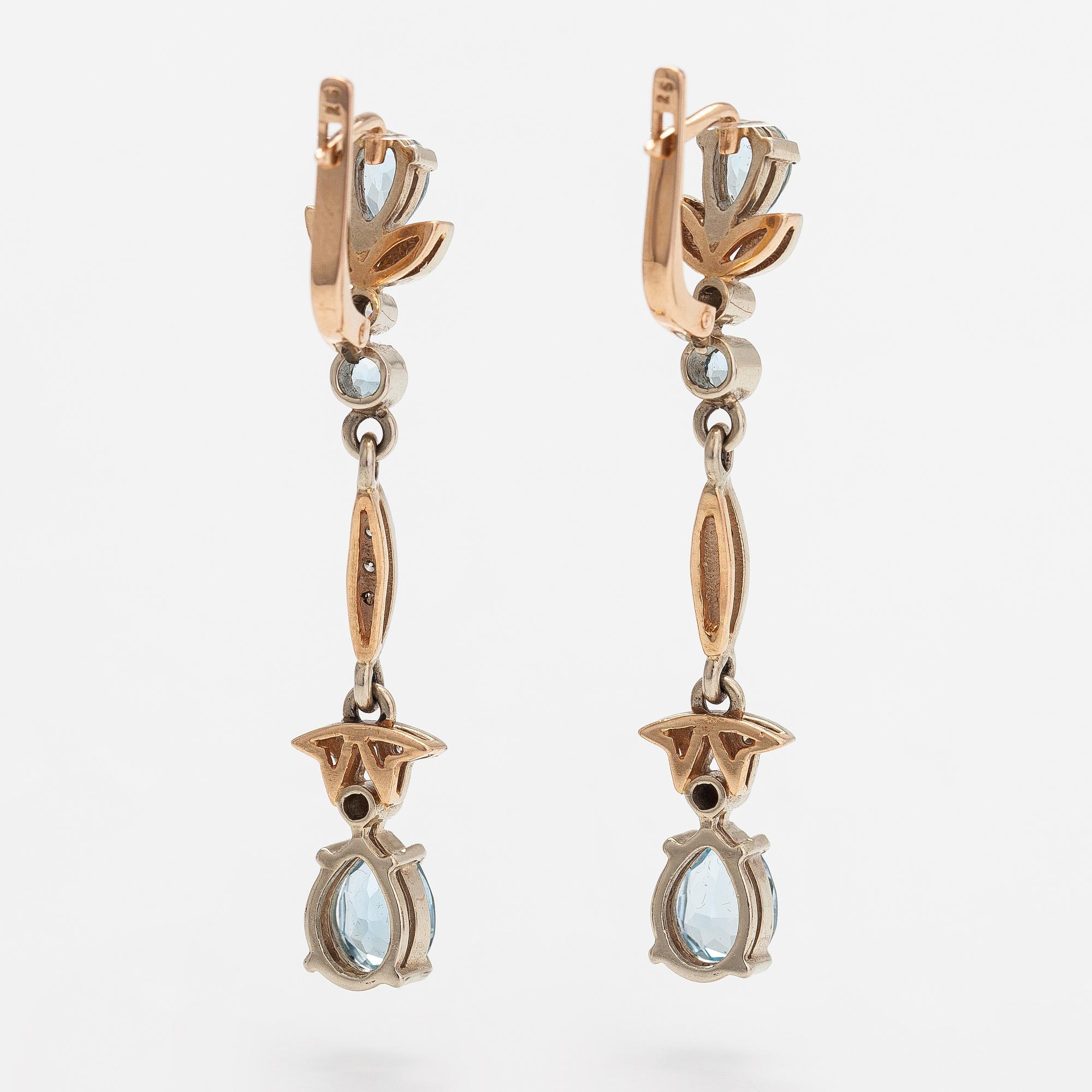 A pair of 14K gold earrings with diamonds ca. 0.18 ct in total and topazes.