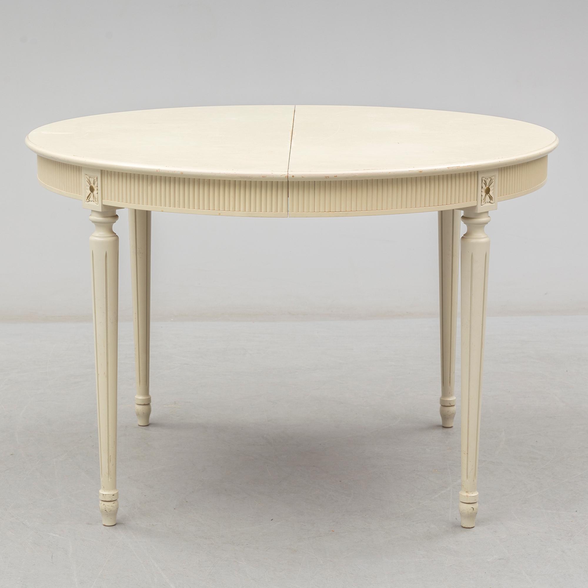 A set of eight chairs and a dining table. Gustavian style, second half of the 20th century. 2 leaves included.