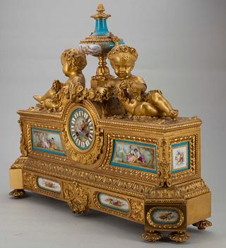 BORDSPENDYL. Förgylld brons med målade porslinsdekorationer i Sevres stil.Ca 1880.