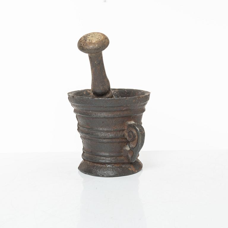 A cast-iron mortar and pestle of renaissance-type, 17th century.