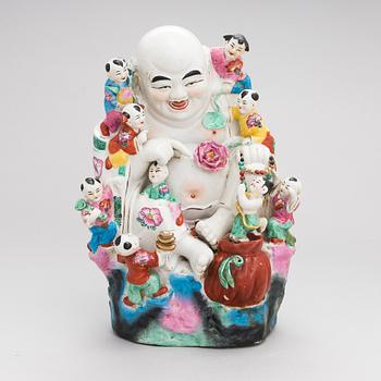 A Chinese porcelain laughing buddha with children, the 20th century.