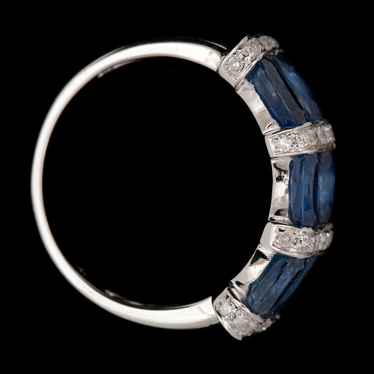RING, 18K vitguld med 6 ovala blå safirer tot ca 2,45ct samt små briljantslipade diamanter. Vikt ca 4g.