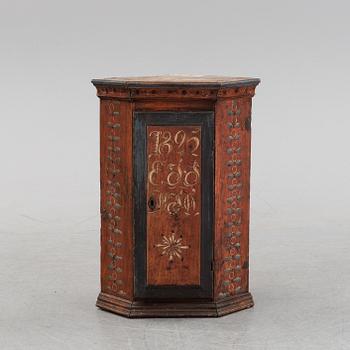 A Swedish painted corner cabinet, dated 1825.