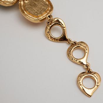 YVES SAINT LAURENT, a gold colored bracelet with glass stones  and two pairs of earclips.