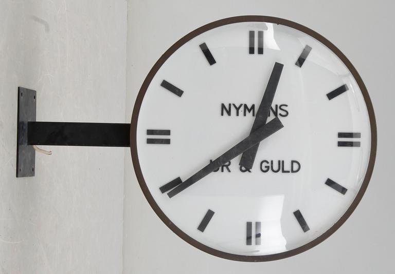 VÄGGKLOCKA / BUTIKSKLOCKA, Nymans Ur&Guld , 1900-talets andra hälft.