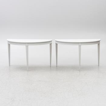 A pair of crescent shaped tables, 20th century.