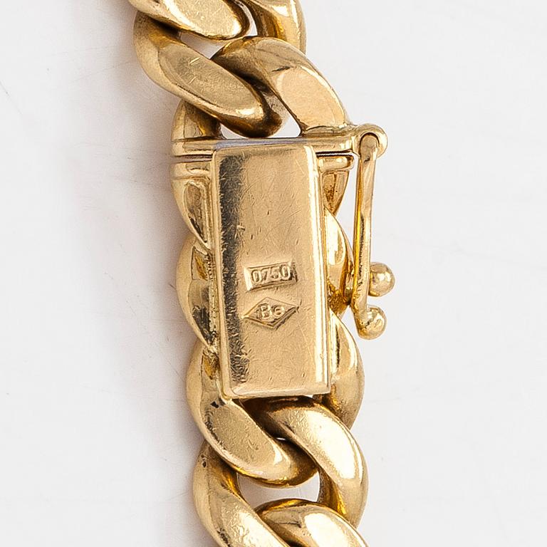 An 18K white/yellow gold curb link bracelet. Foreign marks.