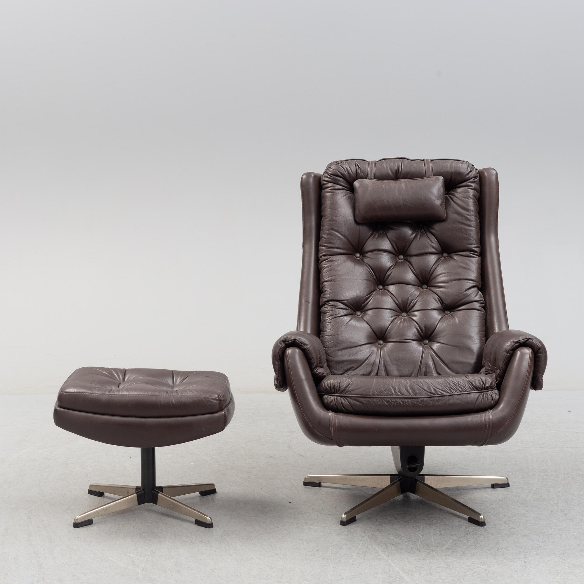 A leather upholstered easy chair with foot stool, 1960's/70's.