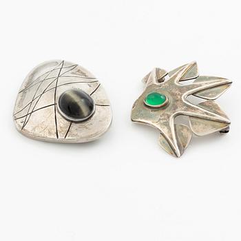 Två broscher, silver och stenar.