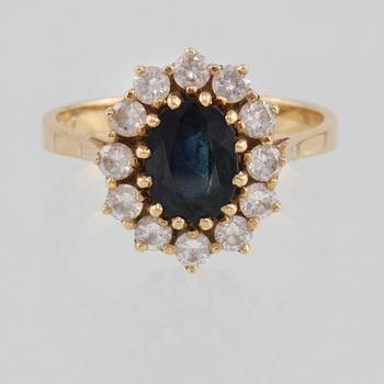 RING, 18K guld med ovalslipad blå safir samt 12 briljantslipade diamanter 0.73 ct, kattfotstämplad. Vikt 5,3 gram.