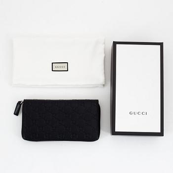 Gucci, an embossed böack leather wallet.