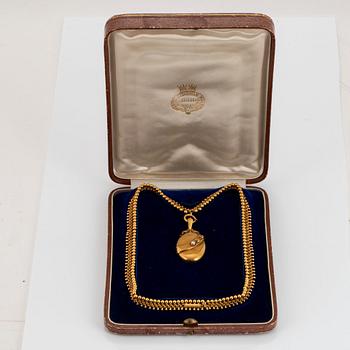 An 18K gold locket set with a pearl and an 18K gold chain.