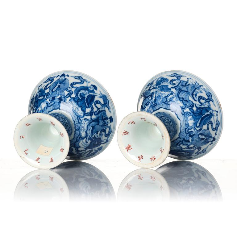 A pair of blue and white 'eight immortals' stemcups, Qing dynasty with Daoguang mark and of the period.