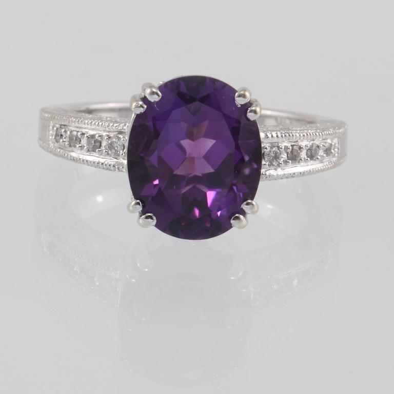 RING, 14K guld med ovalslipad ametist samt åtta briljantslipade diamanter. Vikt 4,6 gram.