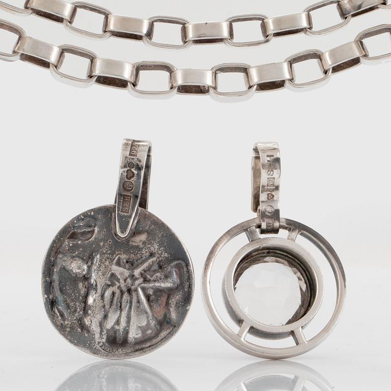 Sven Erik Högberg garnityr två hängen, ett armband och en collier.