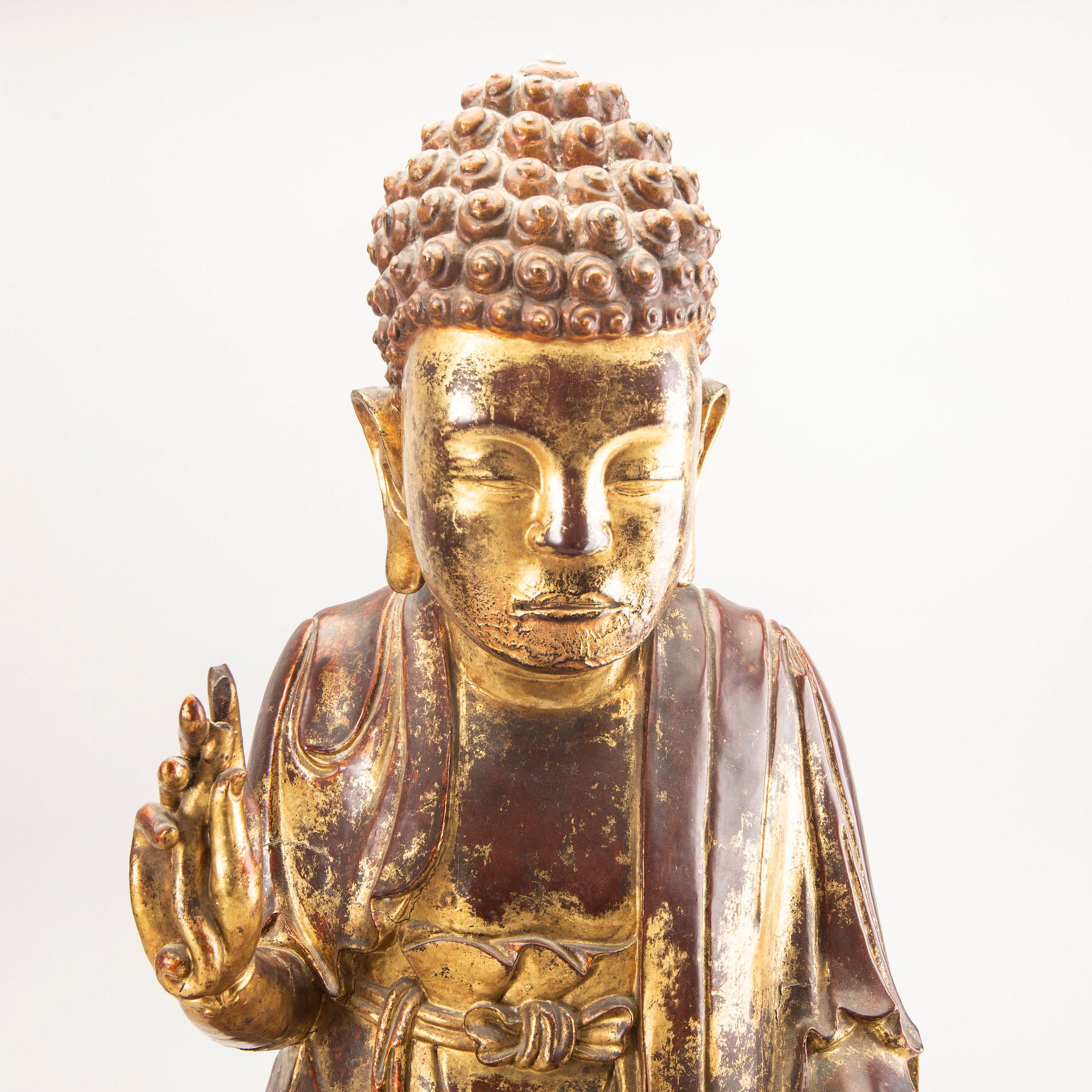 A large gilt and lacquered figure of a seated buddha, Qing dynasty, 19th Century.