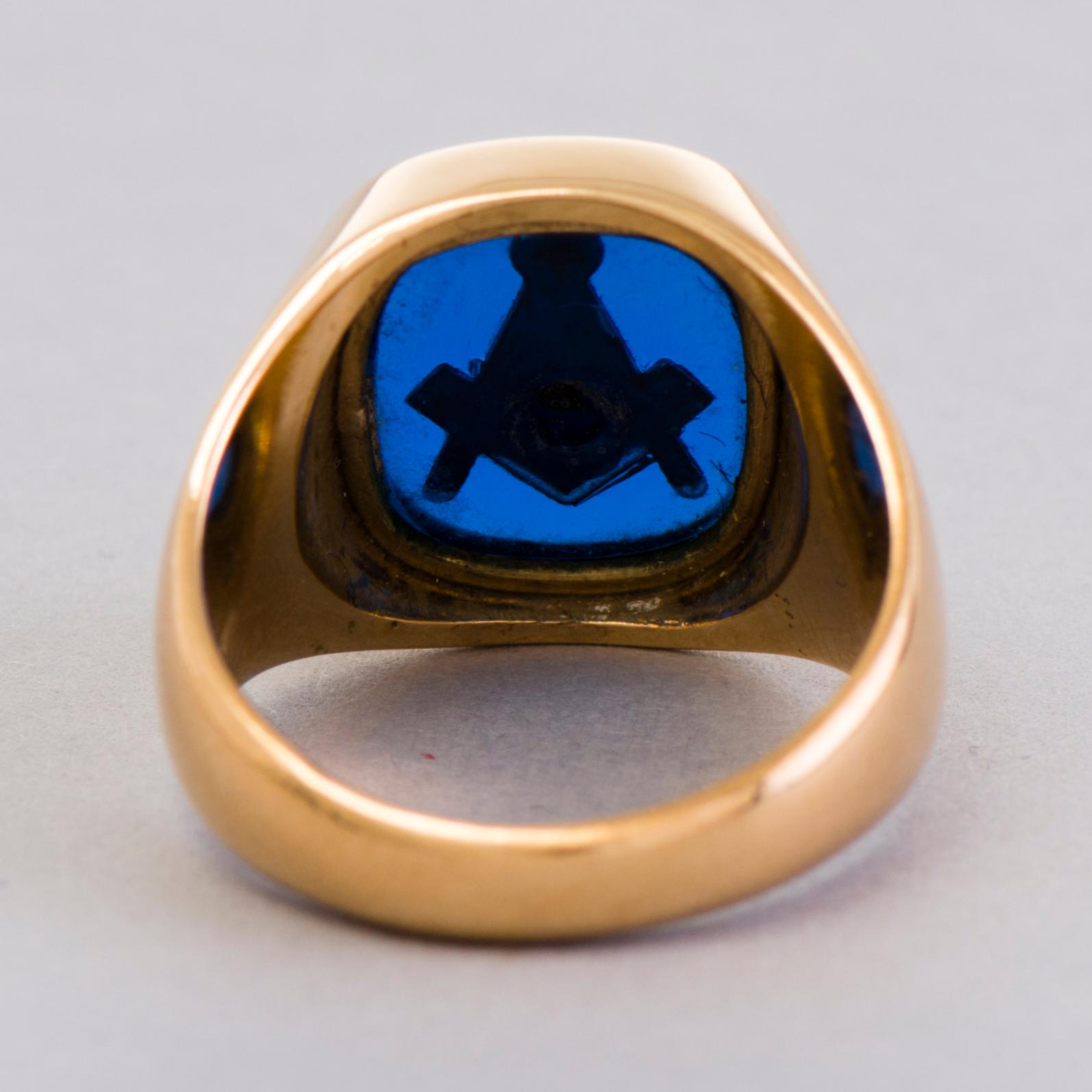 A gold 18K Freemason ring with a synthetic blue sapphire.