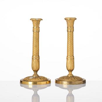 A pair of French Empire ormolu candlesticks, Paris, early 19th century.