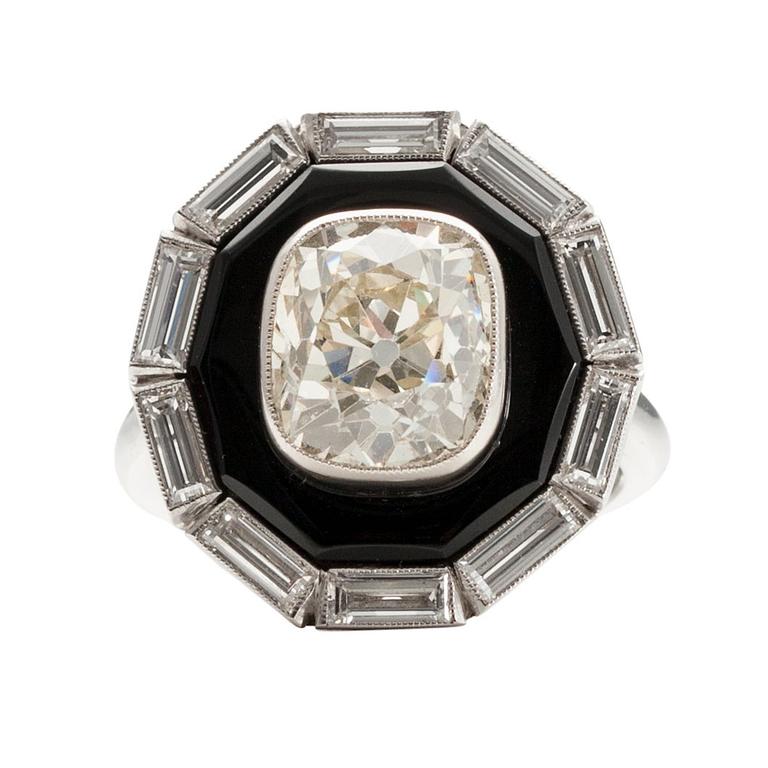 A RING platinum, onyx. Cushion cut diamond 5.20 ct + baguette cut diamonds 2 ct. In total 7.20 ct. France.