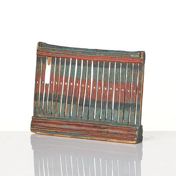 A Swedish carved and polychrome painted weaving tool from Hälsingland, 19th century.